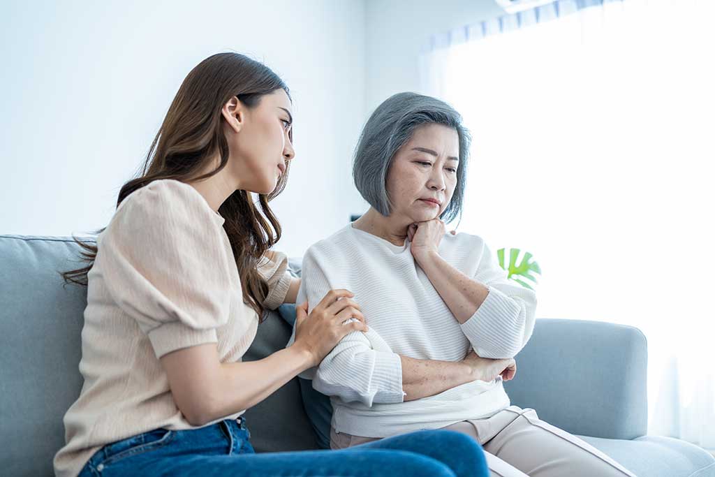 Asian loving daughter comforts upset elderly mother crying for problem